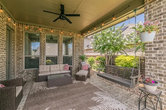 a living room with patio furniture and a floor to ceiling window