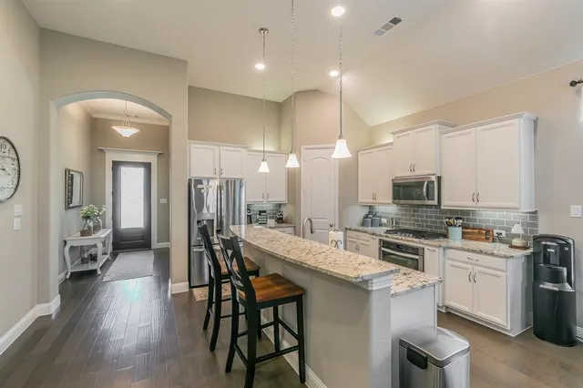 a large kitchen with a table and chairs