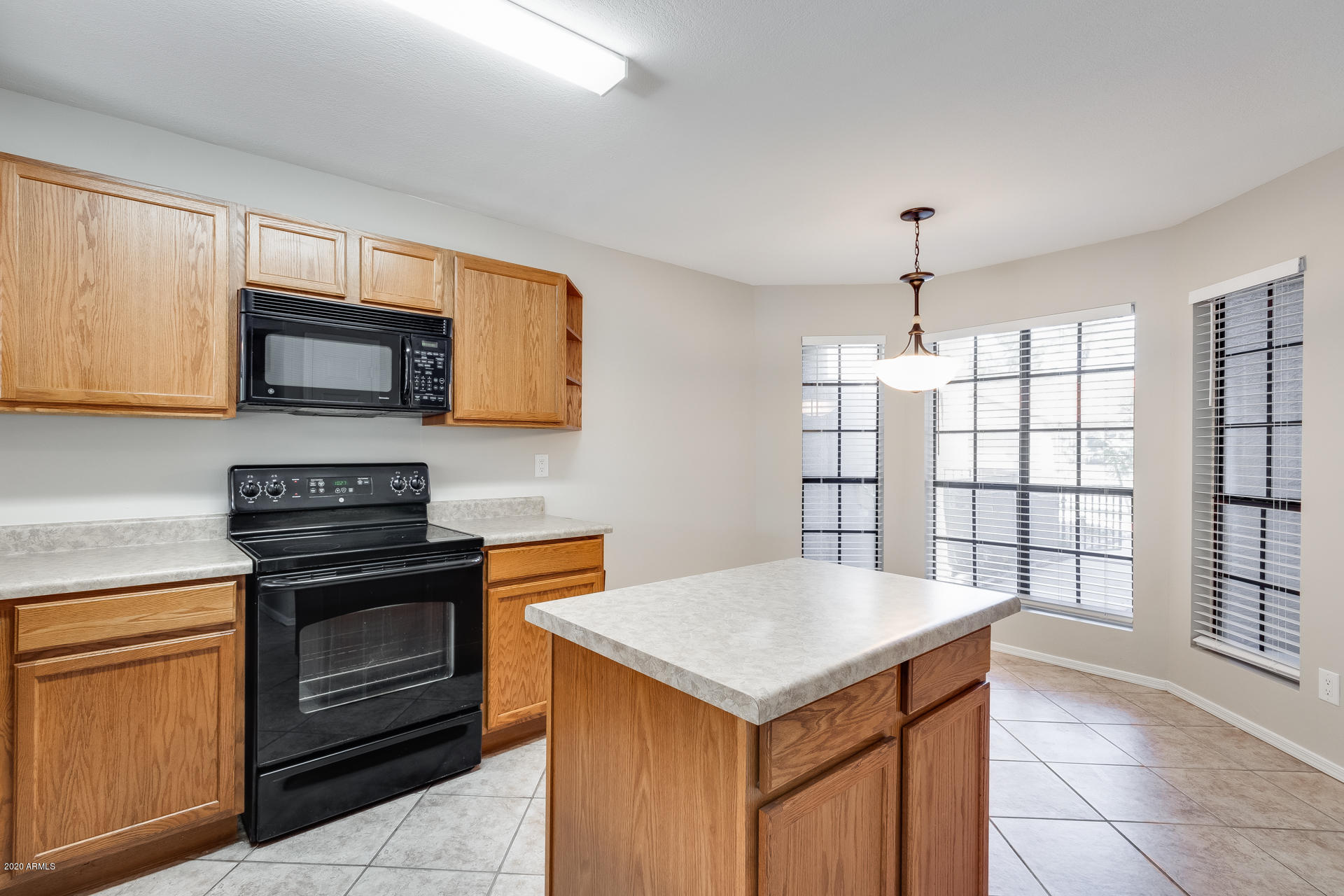 4157 East Agave Road Phoenix, AZ 85044 - Photo 19 of 33 a kitchen with a stove and a microwave