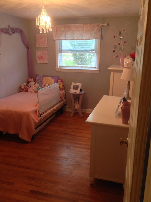 61 Tioga Street Springfield, MA 01128 - Photo 13 of 20 a bedroom with a bed and a chandelier