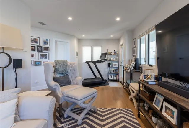 a living room with furniture a flat screen tv and a table
