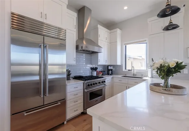 a kitchen with stainless steel appliances granite countertop a sink a stove and a refrigerator