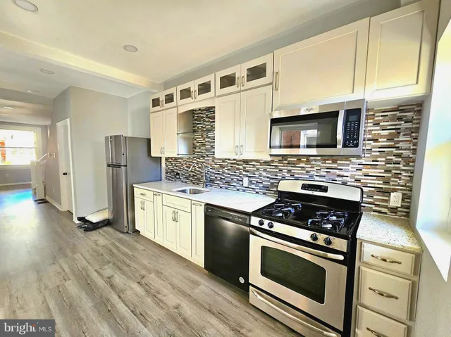 a kitchen with granite countertop cabinets stainless steel appliances and wooden floor