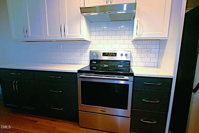 a kitchen with stainless steel appliances granite countertop cabinets and a stove top oven