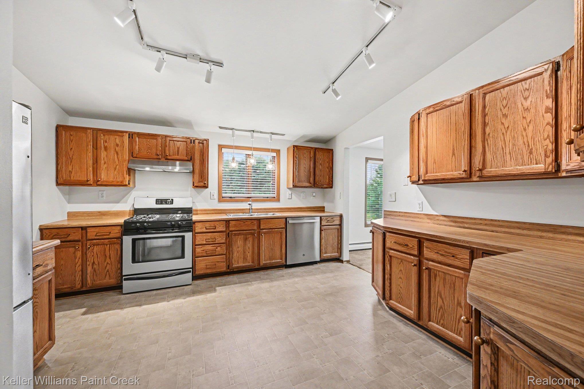 2232 London Bridge Drive Rochester, MI 48307 - Photo 10 of 26 Wood-finish cabinetry paired with wood-finish countertops, stainless steel appliances, and track lighting