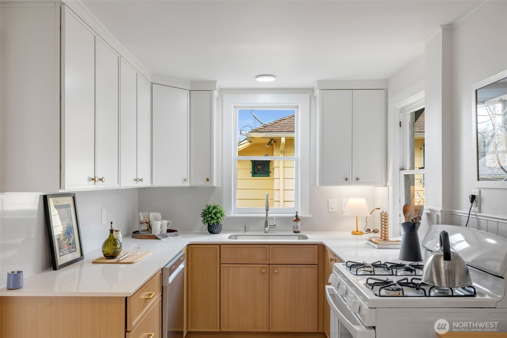 5812 46th Avenue South Seattle, WA 98118 - Photo 13 of 40 a kitchen with a stove and white cabinets