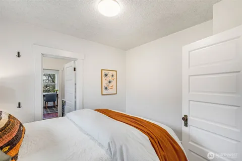 a bedroom with a bed and painting on the wall