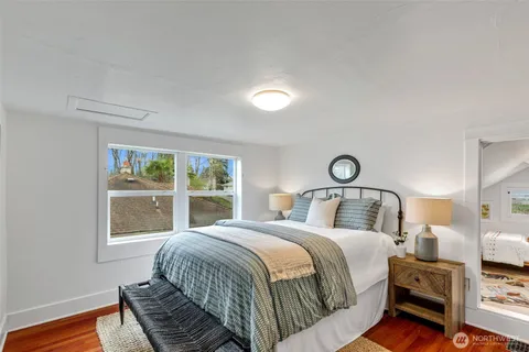 a bedroom with a bed and a lamp with the dresser