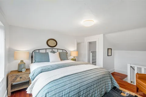 a bedroom with a bed and painting on the wall