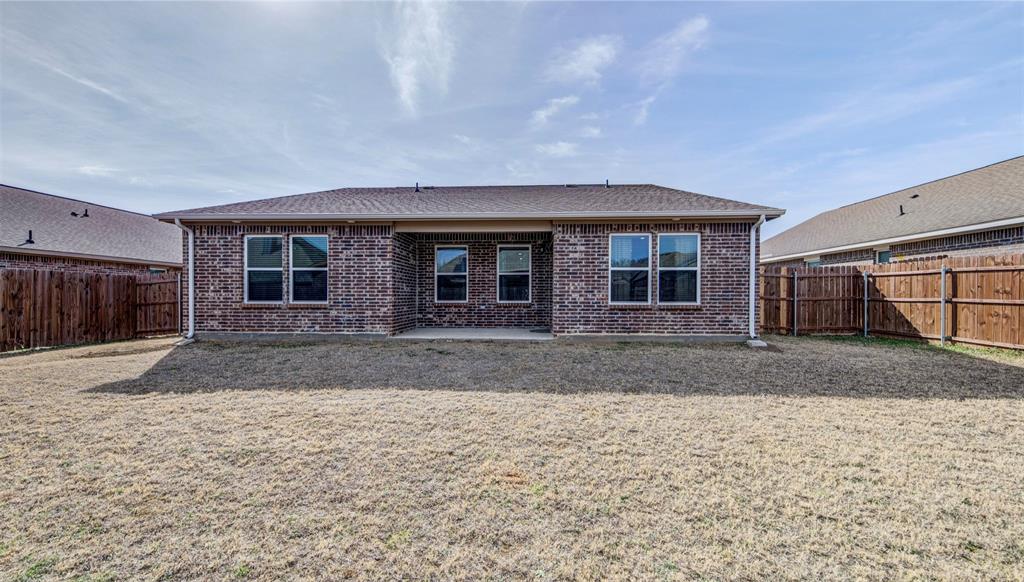 905 Avagail Avenue Springtown, TX 76082 - Photo 24 of 26 Back of property featuring a patio area, brick siding, a fenced backyard, and roof with shingles