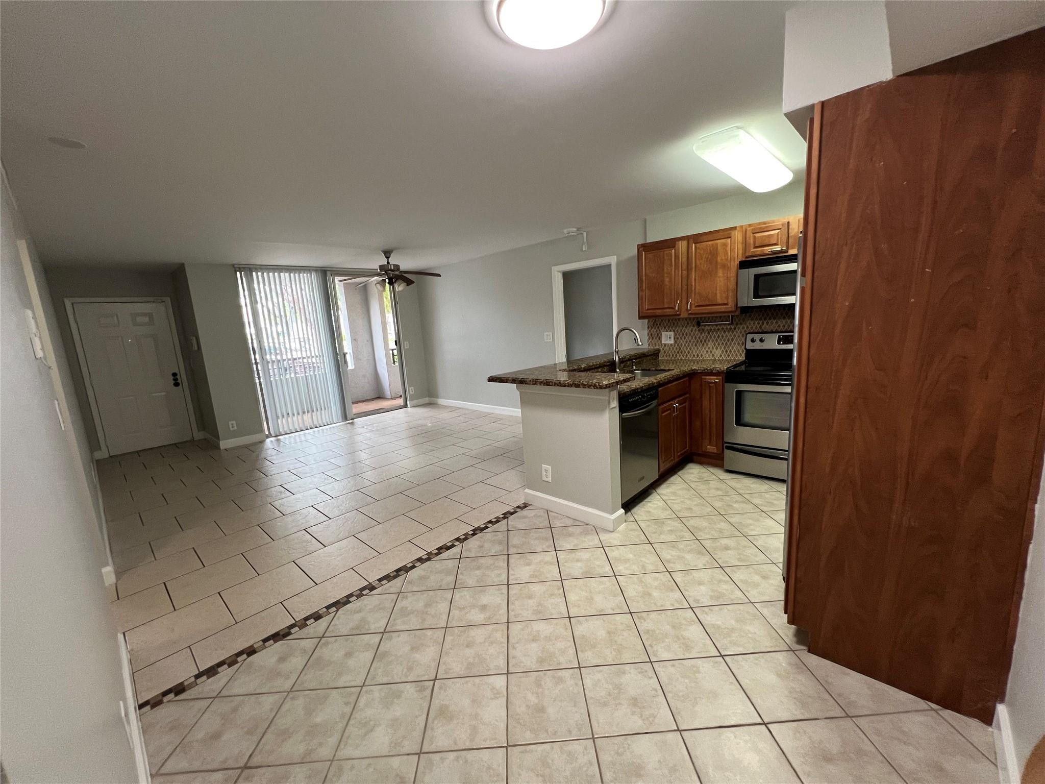 921 Lyons Road, Unit 3105 Coconut Creek, FL 33063 - Photo 18 of 28 a kitchen with stainless steel appliances a sink a stove top oven a counter space and cabinets