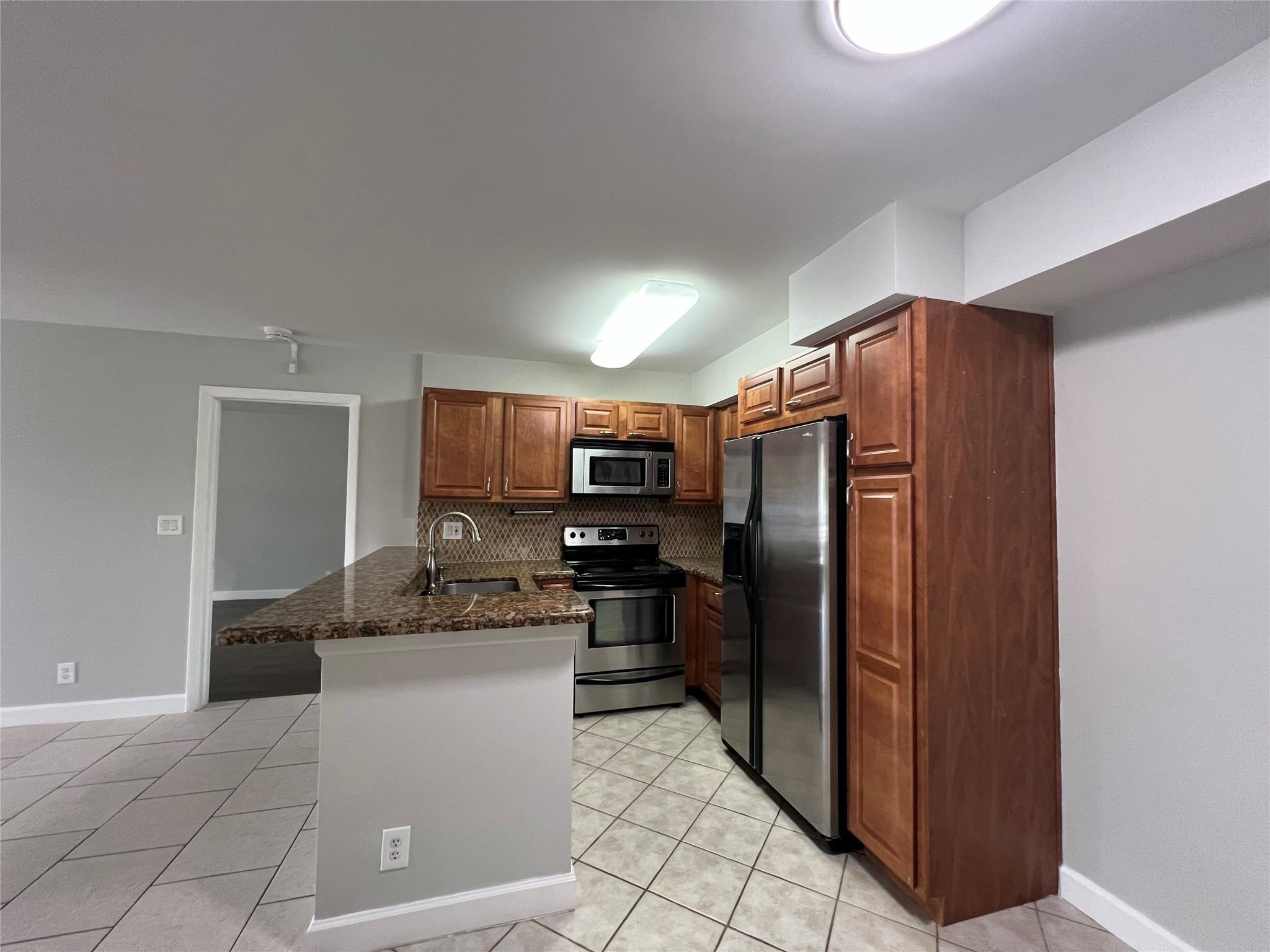 921 Lyons Road, Unit 3105 Coconut Creek, FL 33063 - Photo 4 of 28 a kitchen with stainless steel appliances granite countertop a refrigerator and a sink