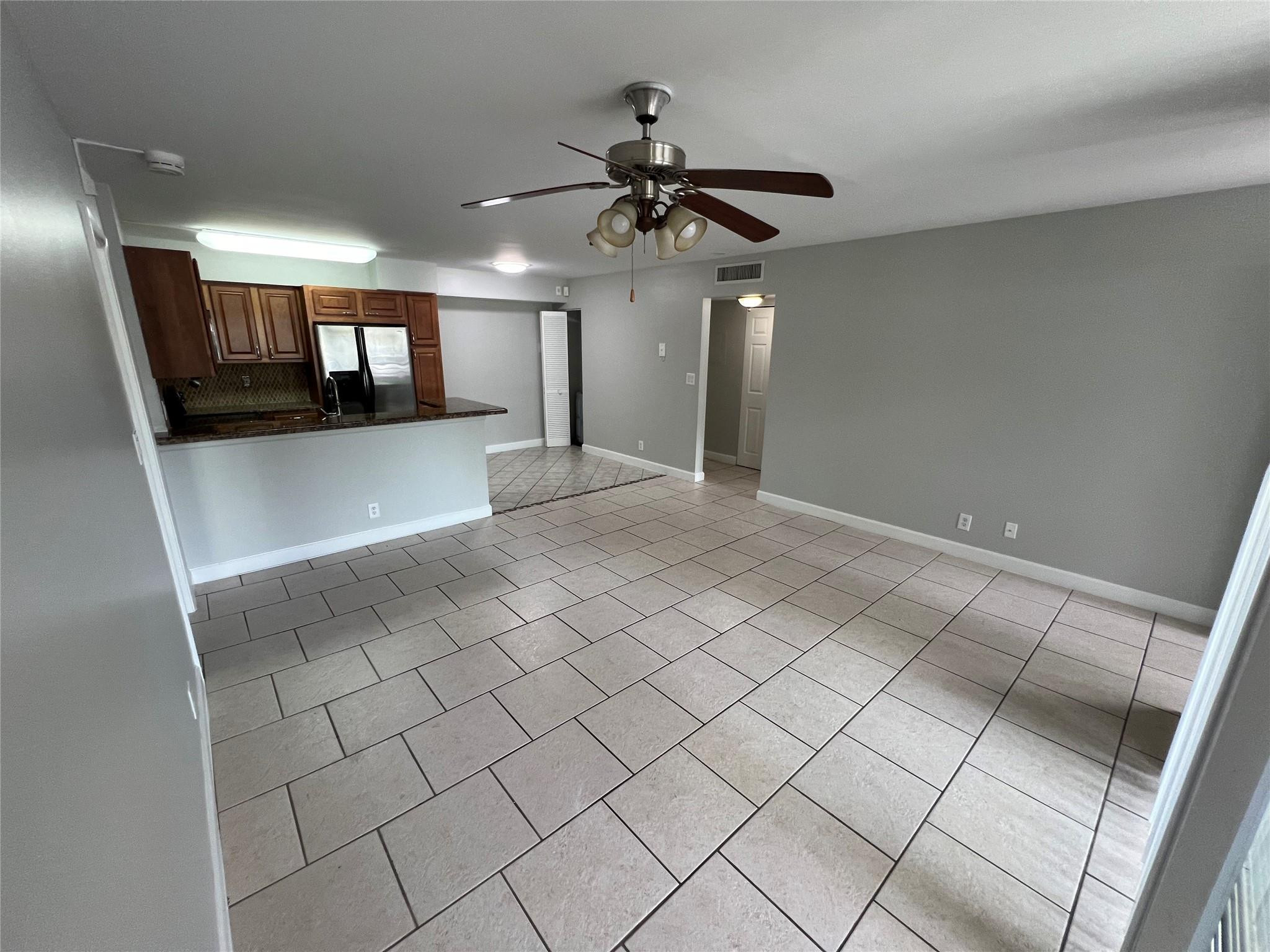 921 Lyons Road, Unit 3105 Coconut Creek, FL 33063 - Photo 5 of 28 a view of an empty room and a chandelier fan
