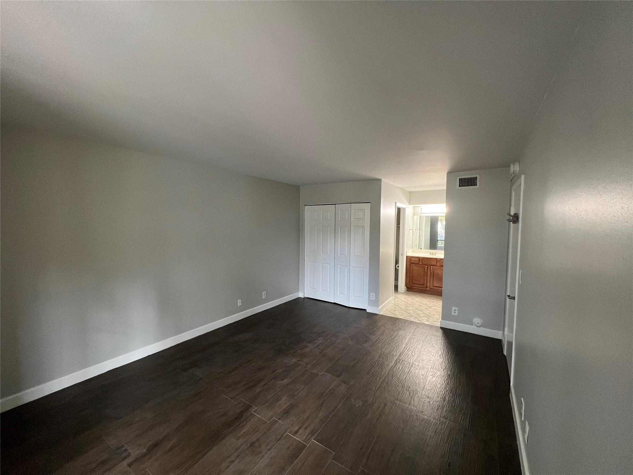 921 Lyons Road, Unit 3105 Coconut Creek, FL 33063 - Photo 7 of 28 an empty room with wooden floor