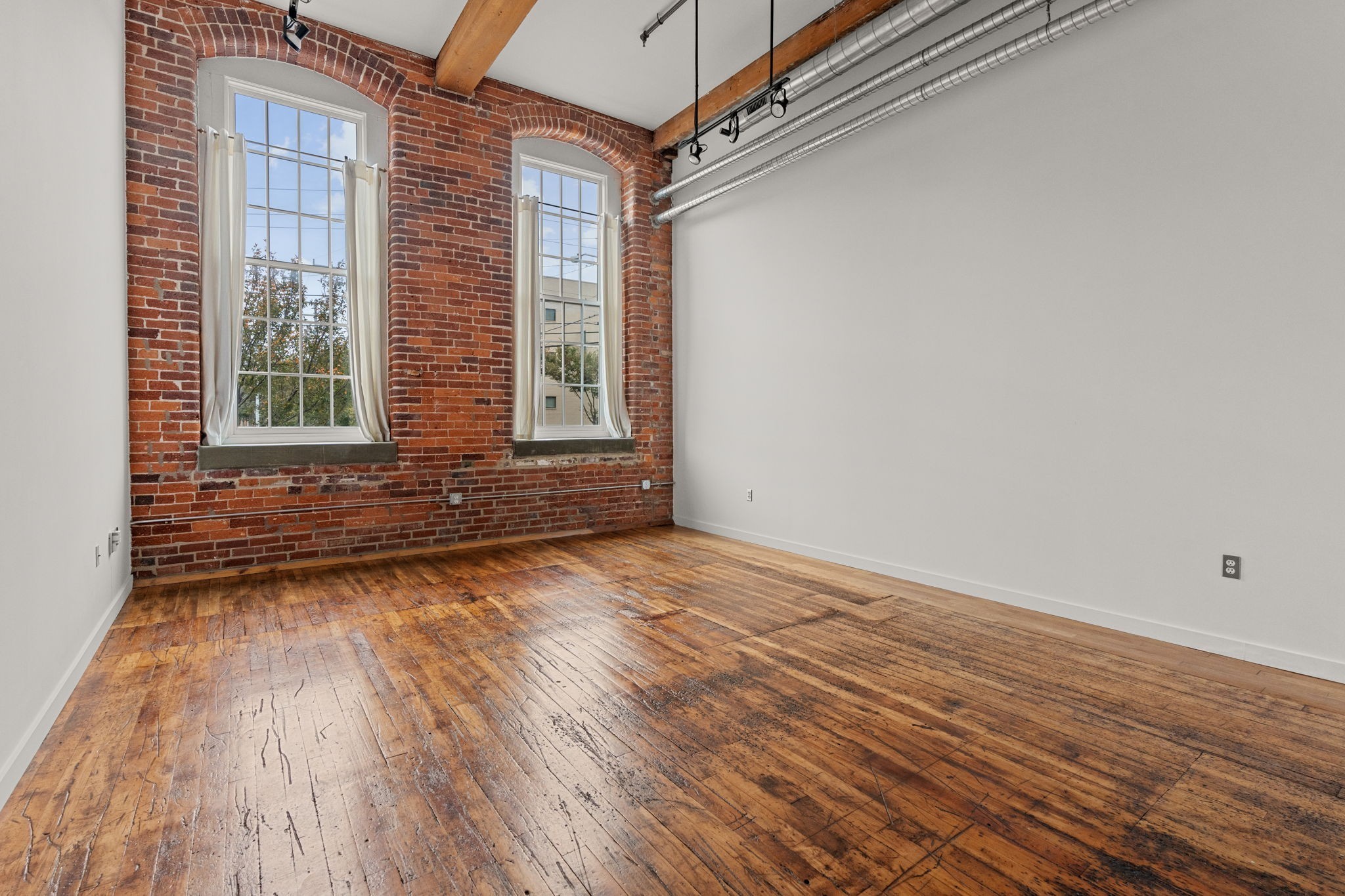 1350 Rosa L Parks Boulevard, Unit 347 Nashville, TN 37208 - Photo 4 of 27 an empty room with wooden floor and windows