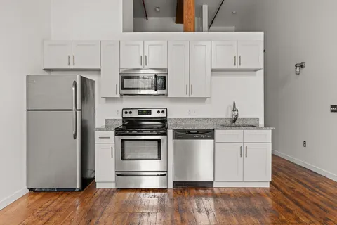 a kitchen with white cabinets and stainless steel appliances