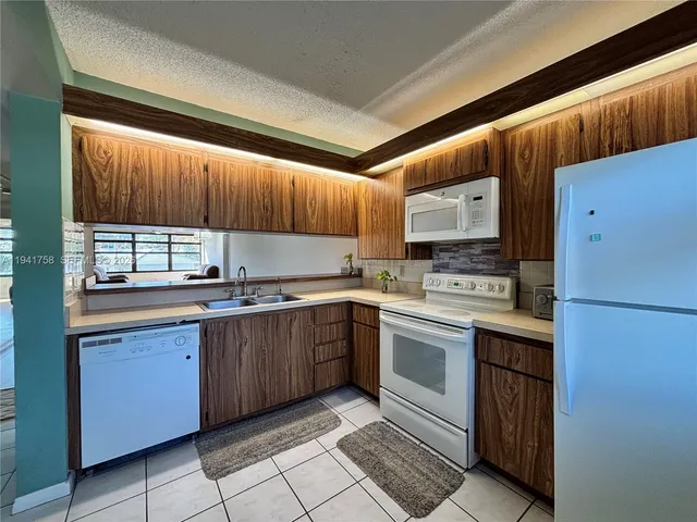 a kitchen with a sink a stove and cabinets