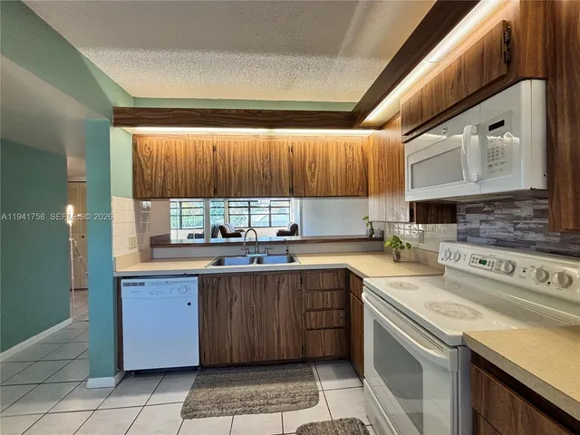 a kitchen with a sink window and cabinets