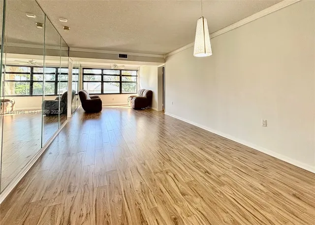 a view of a living room with wooden floor and a floor to ceiling window