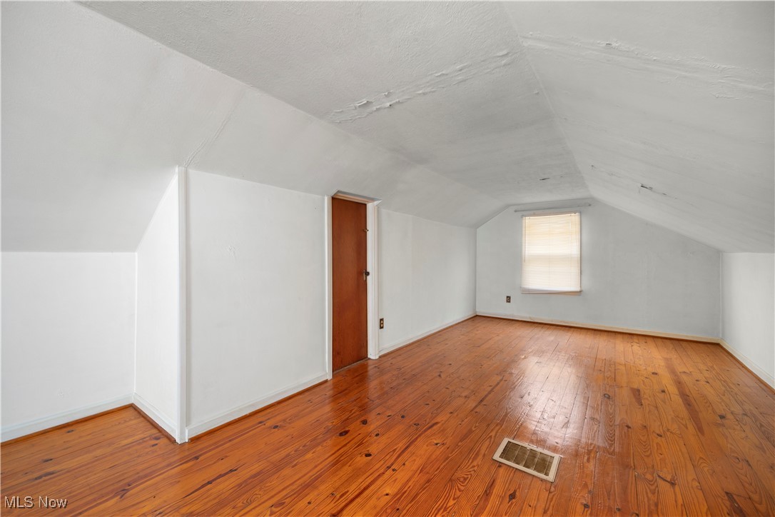 25950 Bagley Road Olmsted Falls, OH 44138 - Photo 22 of 32 Additional living space with lofted ceiling, hardwood / wood-style flooring, and a textured ceiling