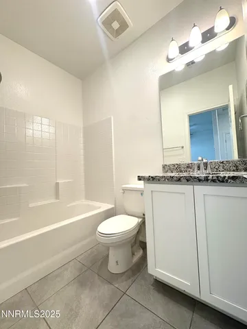 a view of an empty room and chandelier fan