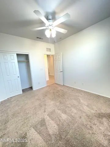 an empty room with a window and a ceiling fan
