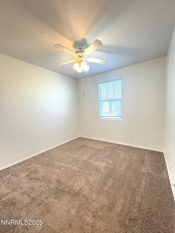 an empty room with a chandelier fan and closet area