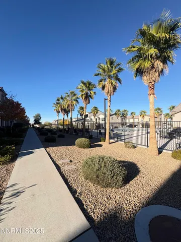 a front view of a house with a yard and palm trees