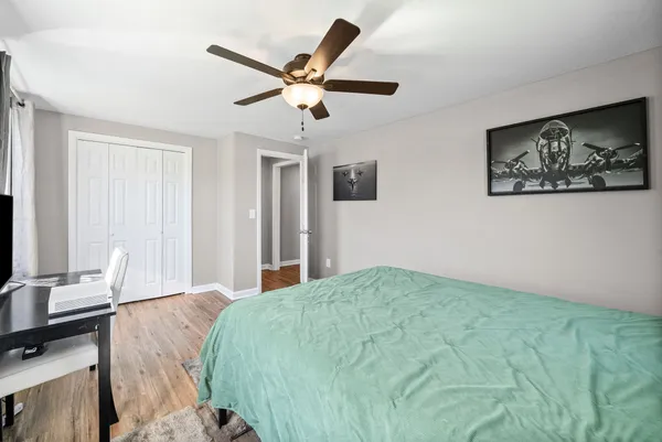 a bedroom with a large bed and a chandelier