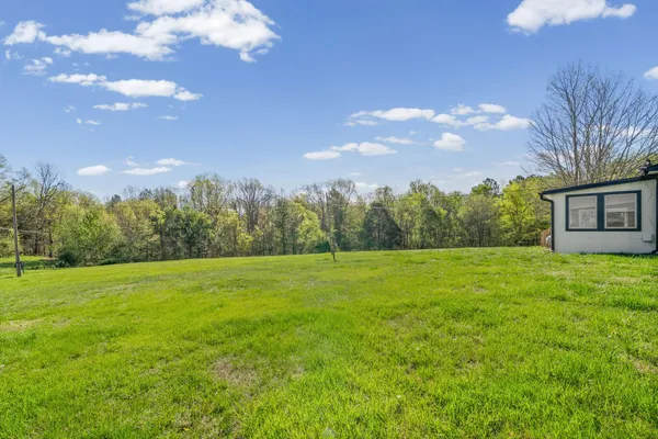 a view of a big yard with a house in the background