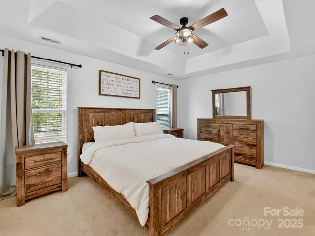 a bedroom with a bed chandelier and a window