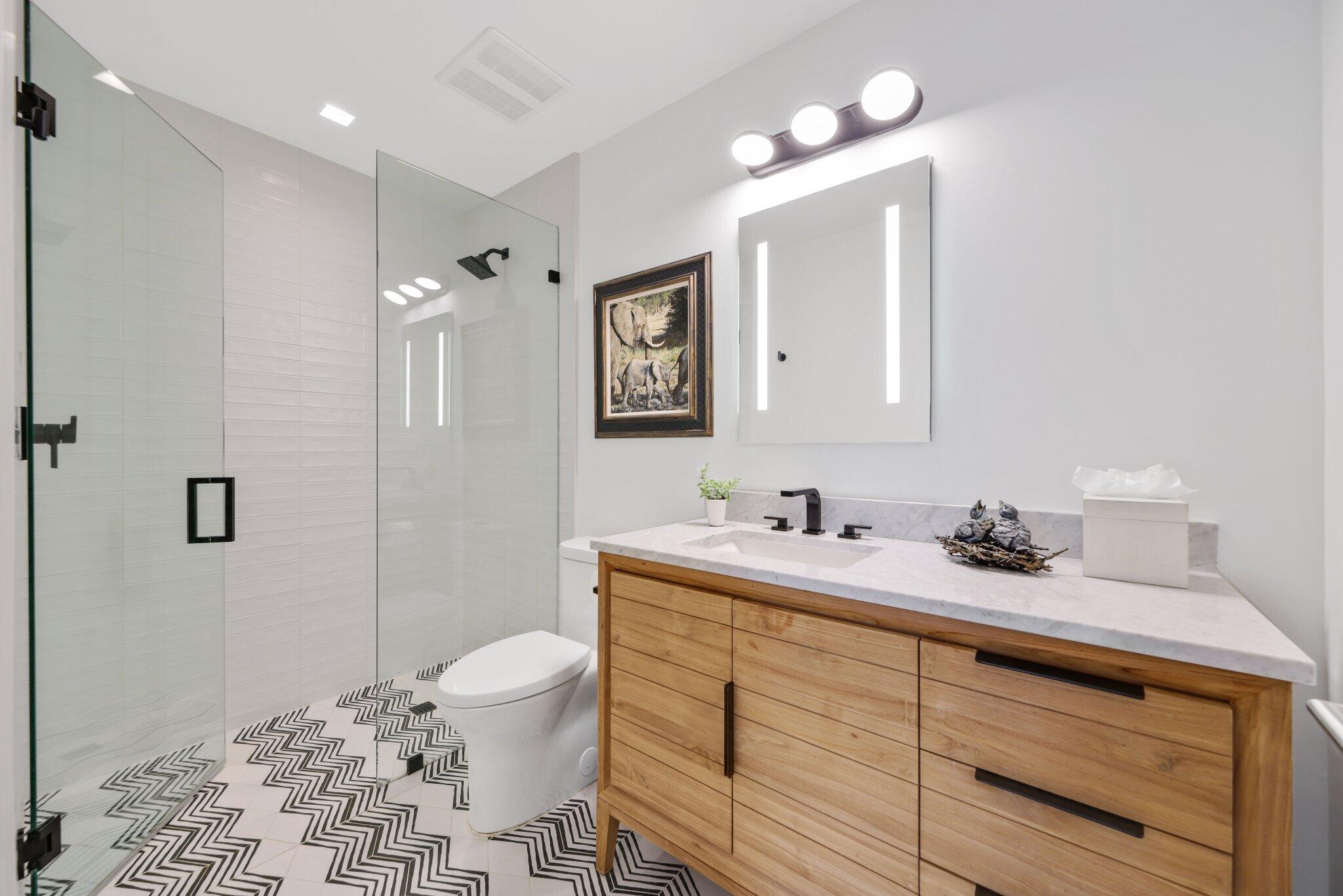 6110 North Ocean Boulevard, Unit 39 Ocean Ridge, FL 33435 - Photo 36 of 59 a bathroom with a granite countertop sink a toilet and a mirror