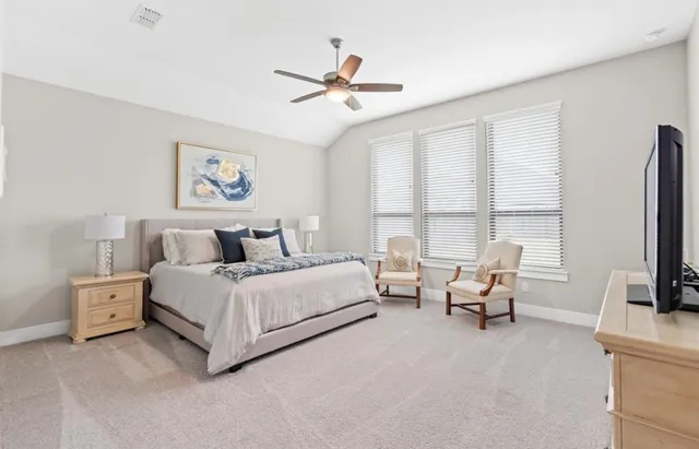 a spacious bedroom with a bed and a large window