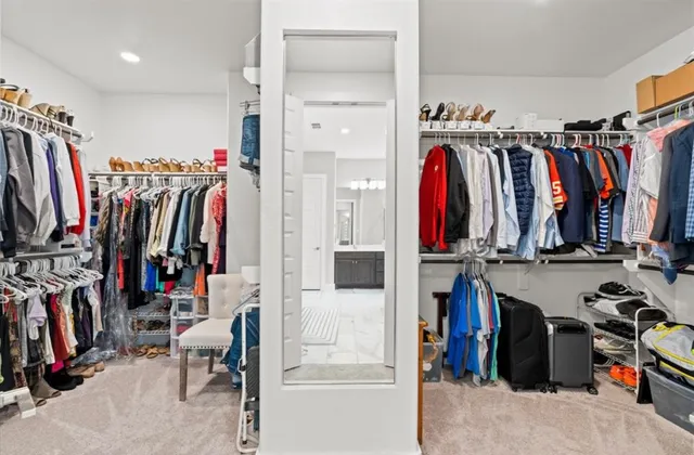 a view of walk in closet with clothes