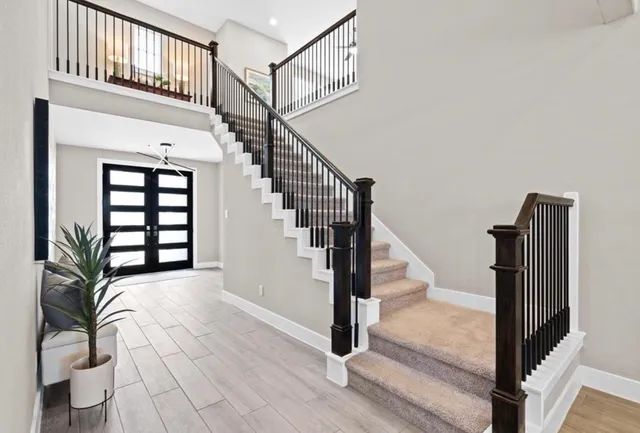 a view of staircase with lots of frames on wall and a window