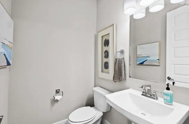 a bathroom with a sink mirror and toilet