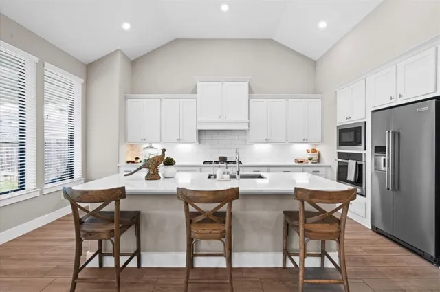 a kitchen with stainless steel appliances a dining table and chairs