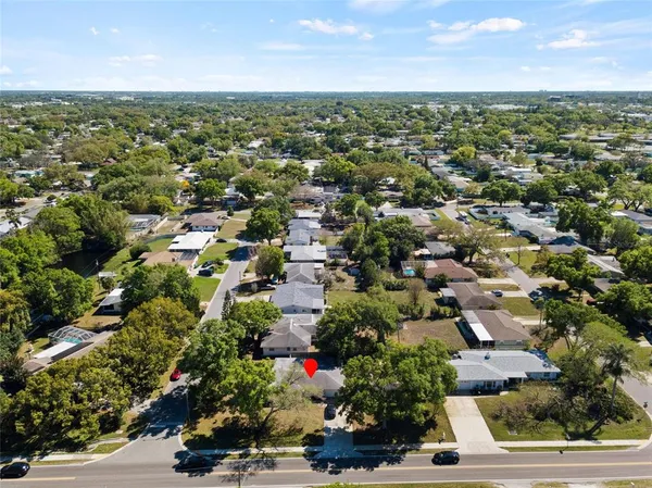 an aerial view of residential houses with outdoor space and trees