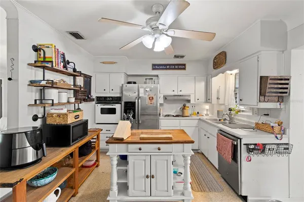 a kitchen that has a lot of cabinets in it and appliances