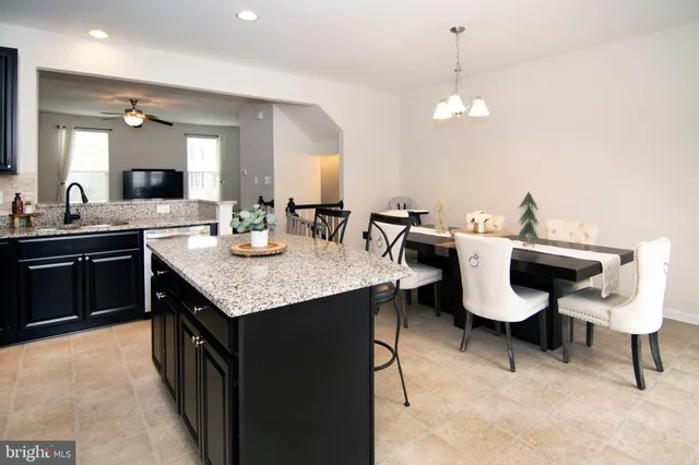 a kitchen with granite countertop sink table and chairs
