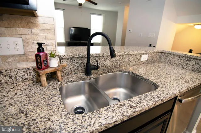 a kitchen with a granite countertop sink and natural light