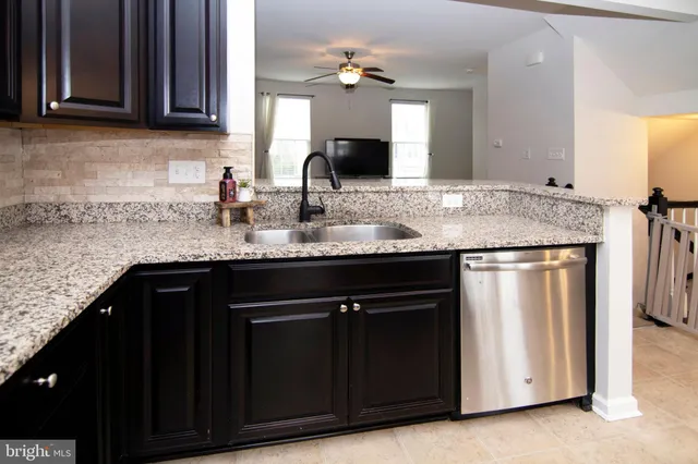 a kitchen with granite countertop a sink stainless steel appliances and cabinets