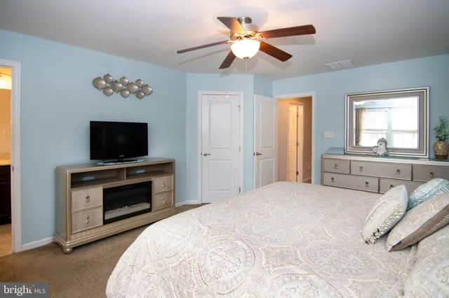a spacious bedroom with a bed and a flat screen tv