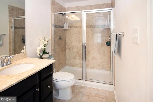 a bathroom with a granite countertop sink toilet and shower