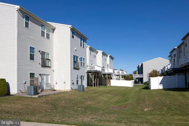 a view of a brick house with large windows and a yard