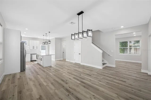 a kitchen with stainless steel appliances a stove a refrigerator and a wooden floor