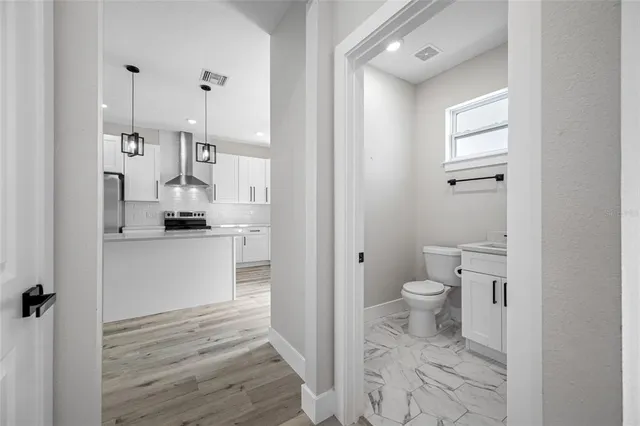 a view of a hallway with wooden floor and closet