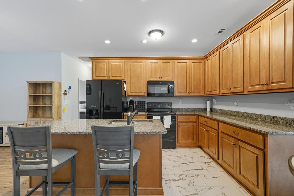 716 Old Pleasant Valley Road Talking Rock, GA 30175 - Photo 30 of 58 a kitchen with stainless steel appliances kitchen island granite countertop a stove a refrigerator a sink dishwasher a dining table and chairs with wooden floor