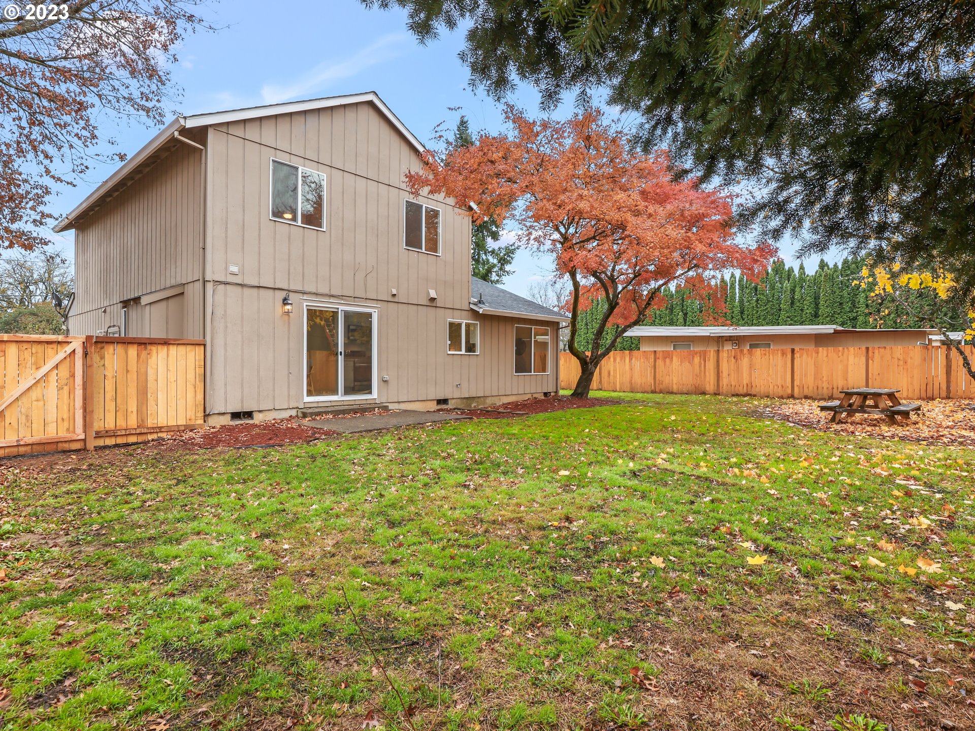 1203 Southeast Barnes Road Gresham, OR 97080 - Photo 35 of 43 a view of a backyard with large tree and wooden fence