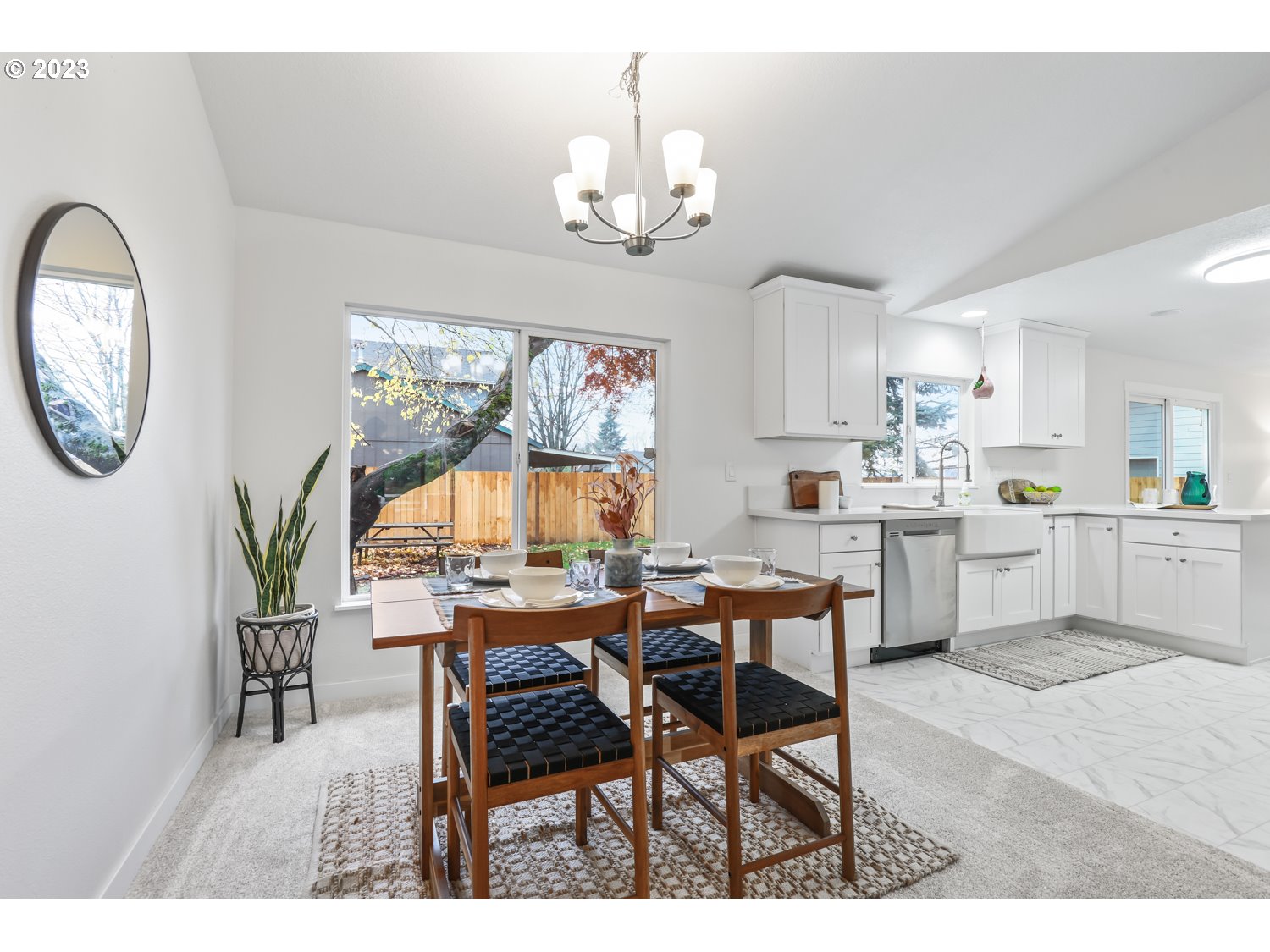 1203 Southeast Barnes Road Gresham, OR 97080 - Photo 6 of 43 a dining room with wooden floor a chandelier a wooden table and chairs